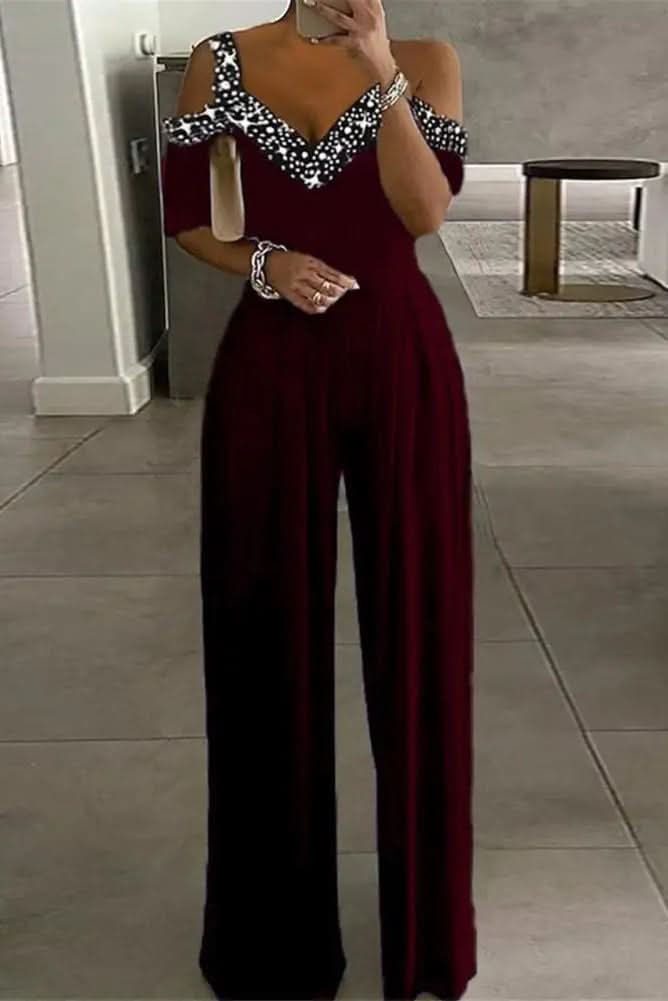 Women's glamorous black rhinestone jumpsuit for evening wear, sparkling one-piece party outfit, elegant special occasion.