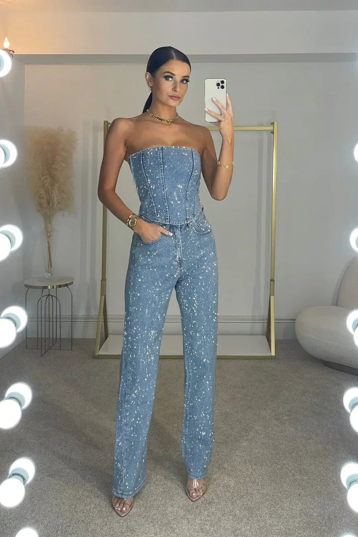 Model wearing women's glitter crop top and high-waist jeans. Chic party outfit for a night out.
