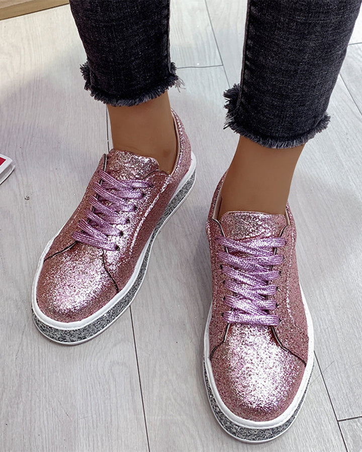 Close-up of women's glitter platform sneakers, highlighting the shimmering fabric & sturdy sole.