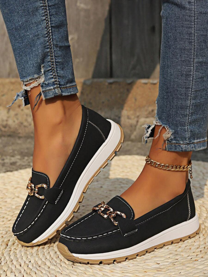 Elevated women's flatform loafers. Slip-on style featuring a bold gold chain and comfortable round toe design.