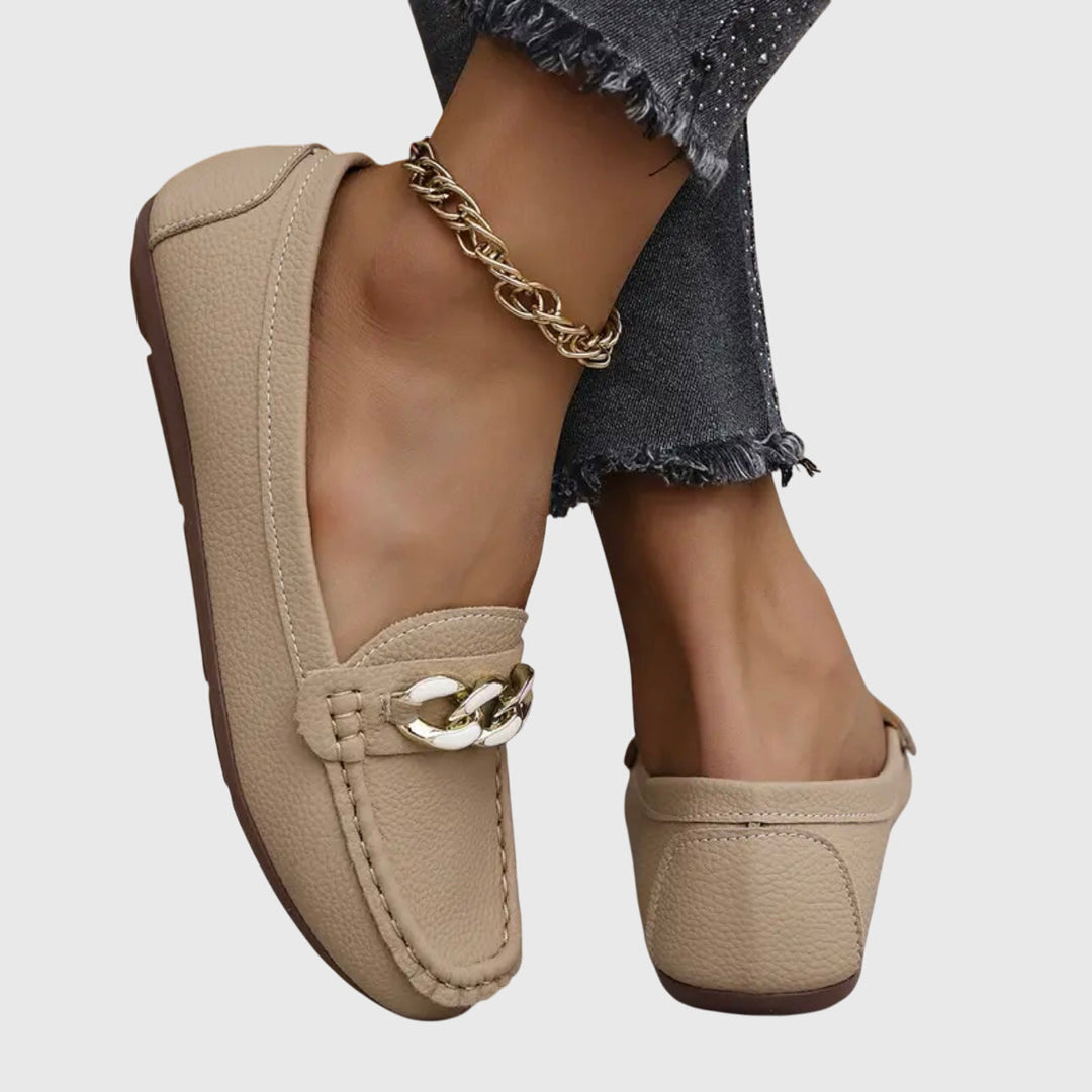 Sophisticated women's elegant footwear: wedge loafers, gold chain, and crystal embellishments.