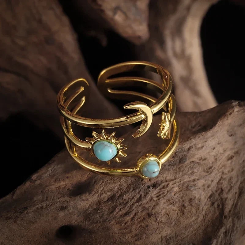 Elegant women's gold-tone celestial ring. Sun, moon, and stars design with a beautiful turquoise gemstone.