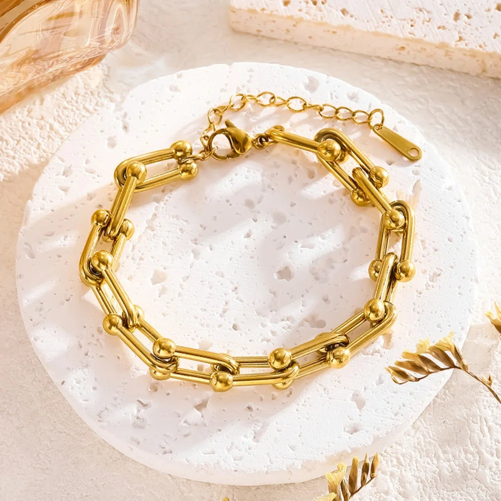 Detail of secure clasp on women's gold link chain jewelry. Gold-plated stainless steel, quality craftsmanship.
