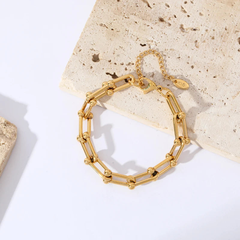 Women's gold link chain jewelry set elevating a casual look. Gold-plated stainless steel necklace & bracelet.