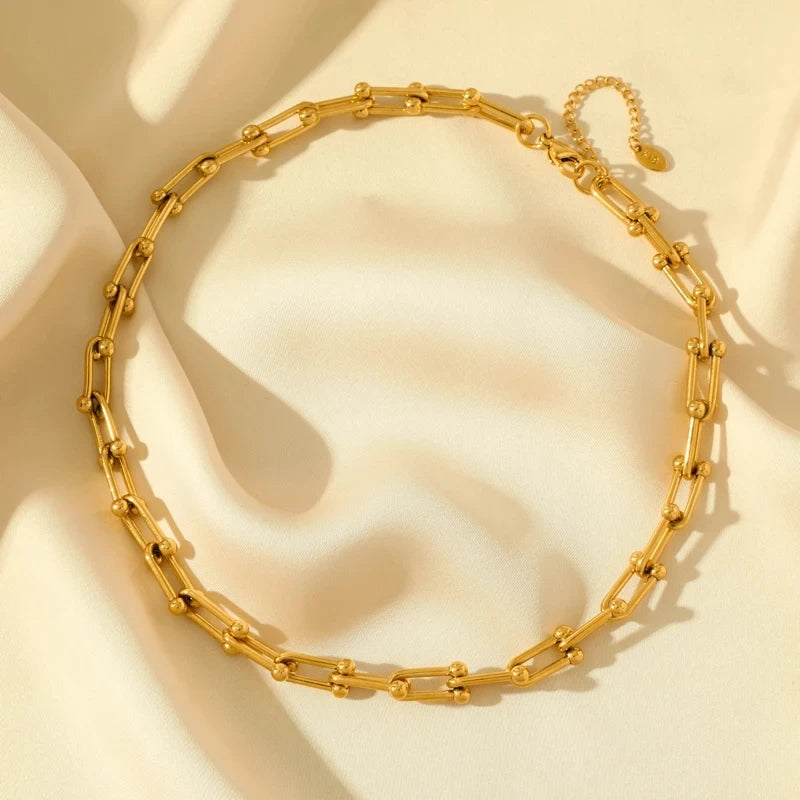 Model showcasing stylish women's gold link chain bracelet. Gold-plated, stainless steel, versatile accessory.