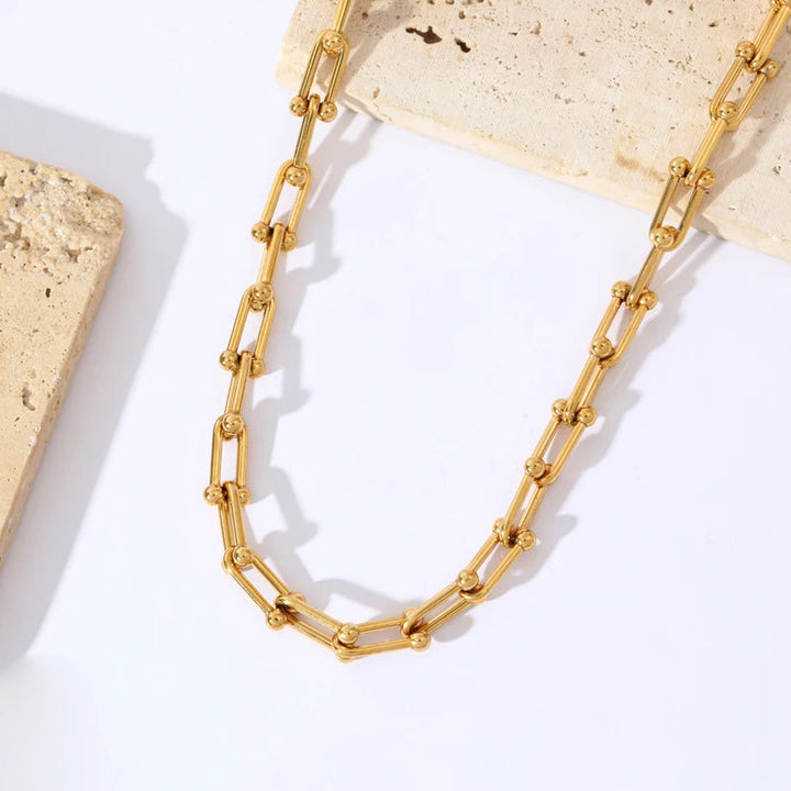 Complete women's gold link chain jewelry set: necklace & bracelet. Gold-plated stainless steel, elegant design.