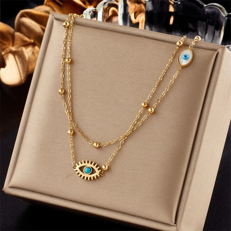 Women's gold stainless steel layered necklace with multiple evil eye protection pendants, a stylish fashion accessory.