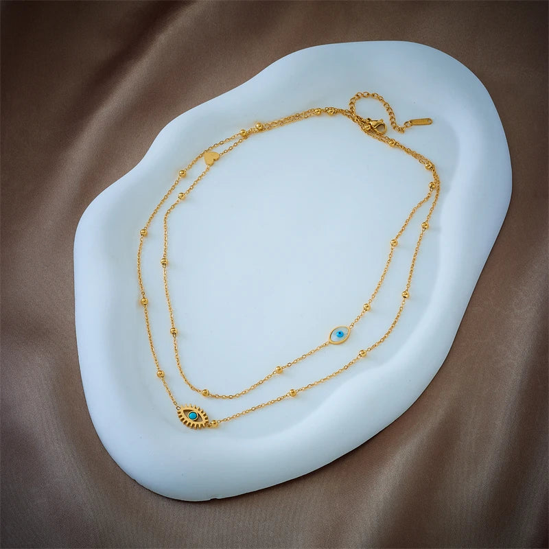 Fashionable women's gold protection necklace with intricate evil eye pendants, a stunning layered stainless steel jewelry piece.