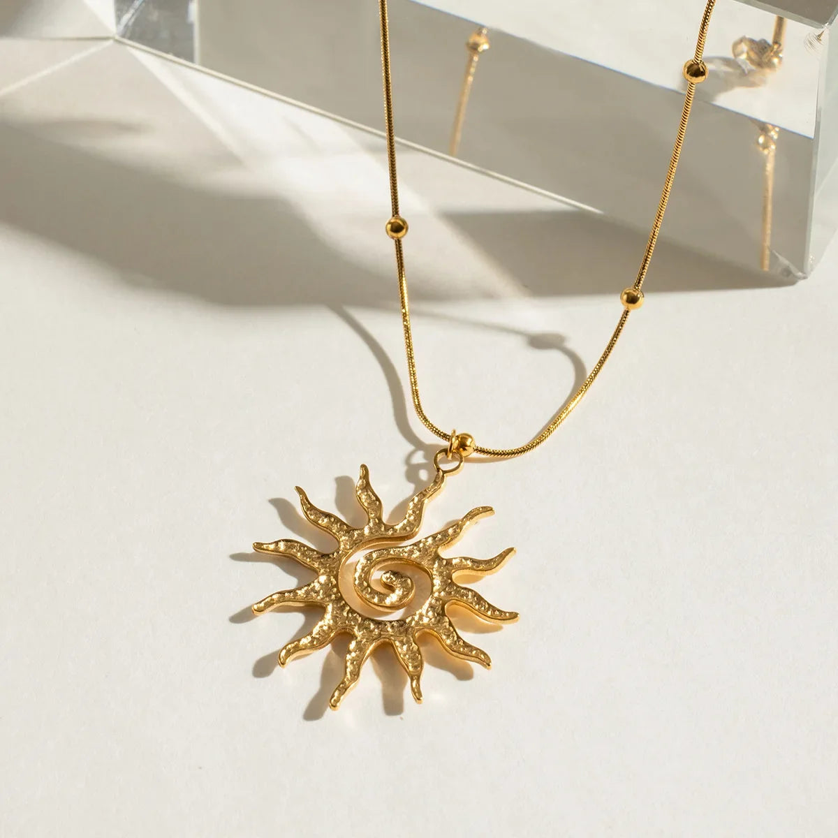 Adjustable gold sun charm necklace for women, capturing bohemian elegance in durable stainless steel jewelry.