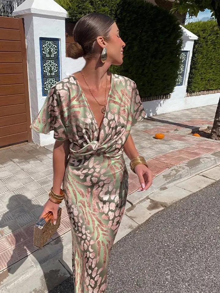 Women's green abstract print wrap midi dress with a relaxed, flowy fit, perfect for summer occasions.