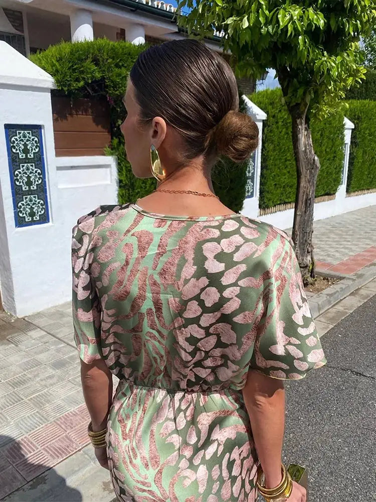 Chic women's midi wrap dress with a vibrant abstract print in green. Relaxed fit for elegant summer style.
