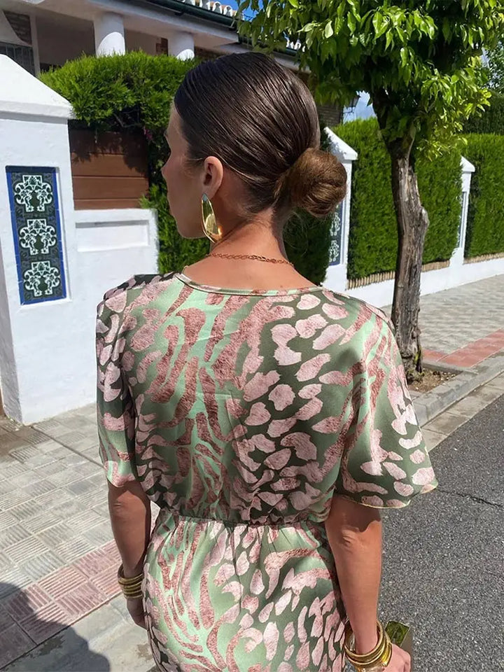 Chic women's midi wrap dress with a vibrant abstract print in green. Relaxed fit for elegant summer style.