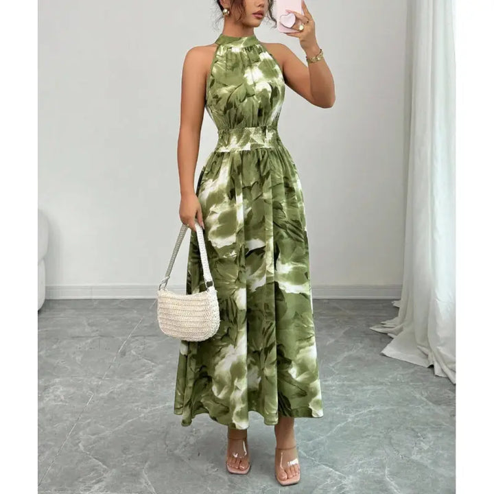 Women's halter neck maxi dress with smocked waist & abstract print. Elegant, flowy summer vacation wear.