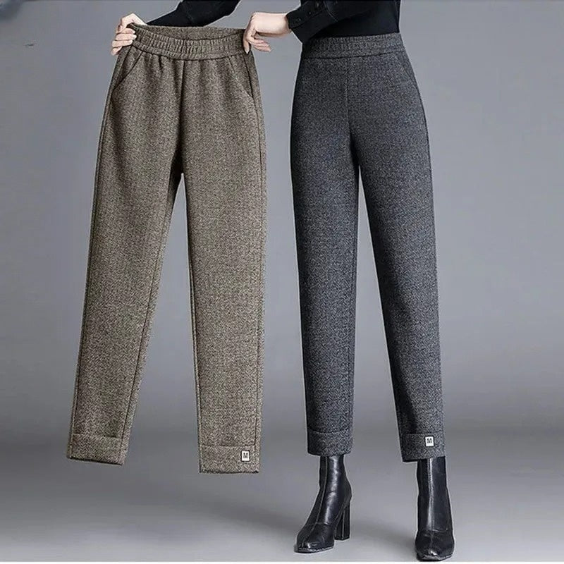 Detail of women's herringbone pattern tailored trousers, showing fabric texture and elegant high-waist cut.