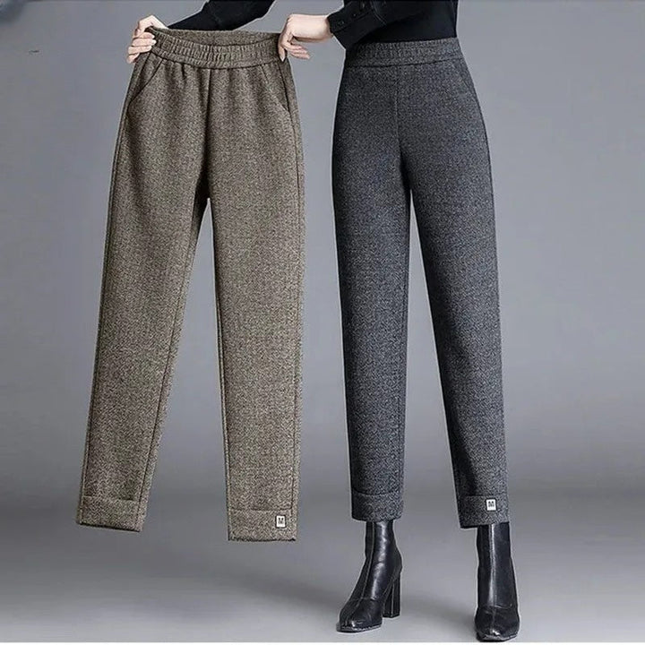 Detail of women's herringbone pattern tailored trousers, showing fabric texture and elegant high-waist cut.
