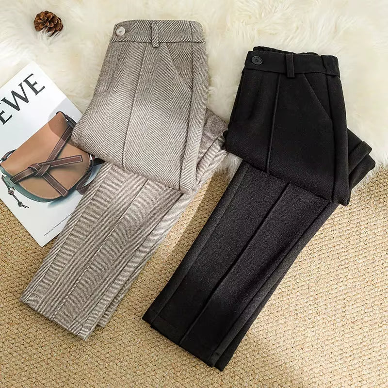 Detail of high-waisted band on women's herringbone tailored trousers, offering a flattering fit.