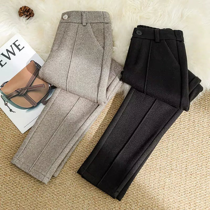 Detail of high-waisted band on women's herringbone tailored trousers, offering a flattering fit.