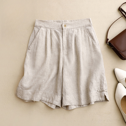 Brown high-waisted pleated summer shorts for women. Comfy, relaxed fit & tied hem detail, ideal for everyday style.