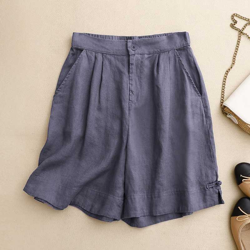 Cream women's high-waisted summer shorts with pleated design. Relaxed fit for warm weather, vacation, or resort wear.