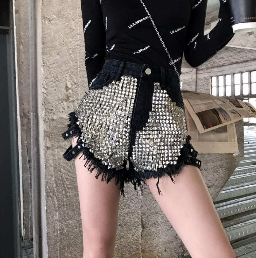 Statement women's high-waisted shorts featuring intricate studs & raw frayed edges. Ideal for a bold summer look.