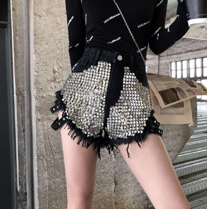 Statement women's high-waisted shorts featuring intricate studs & raw frayed edges. Ideal for a bold summer look.
