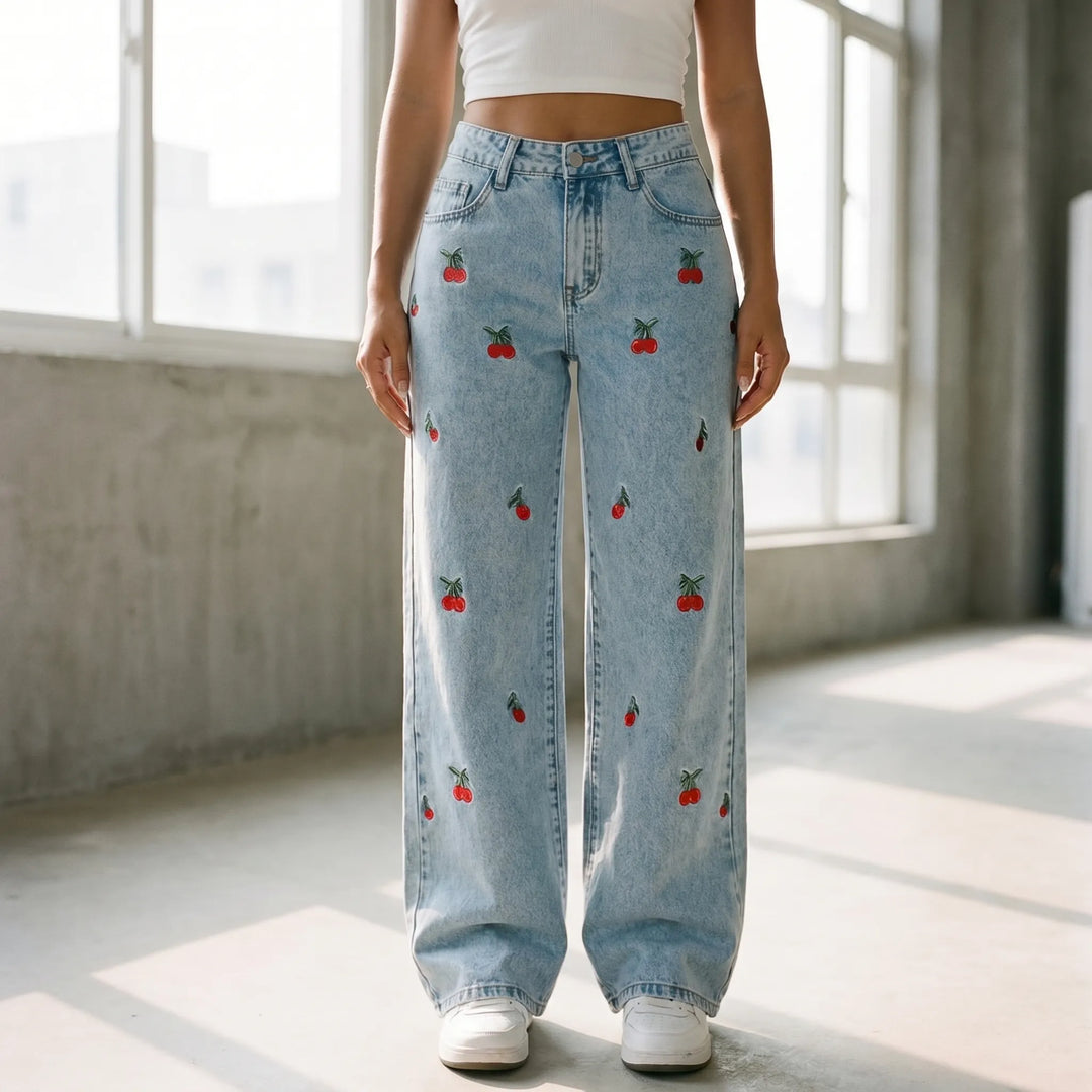 Women's high-waisted wide-leg light wash jeans with delicate cherry embroidery, perfect for casual fashion.