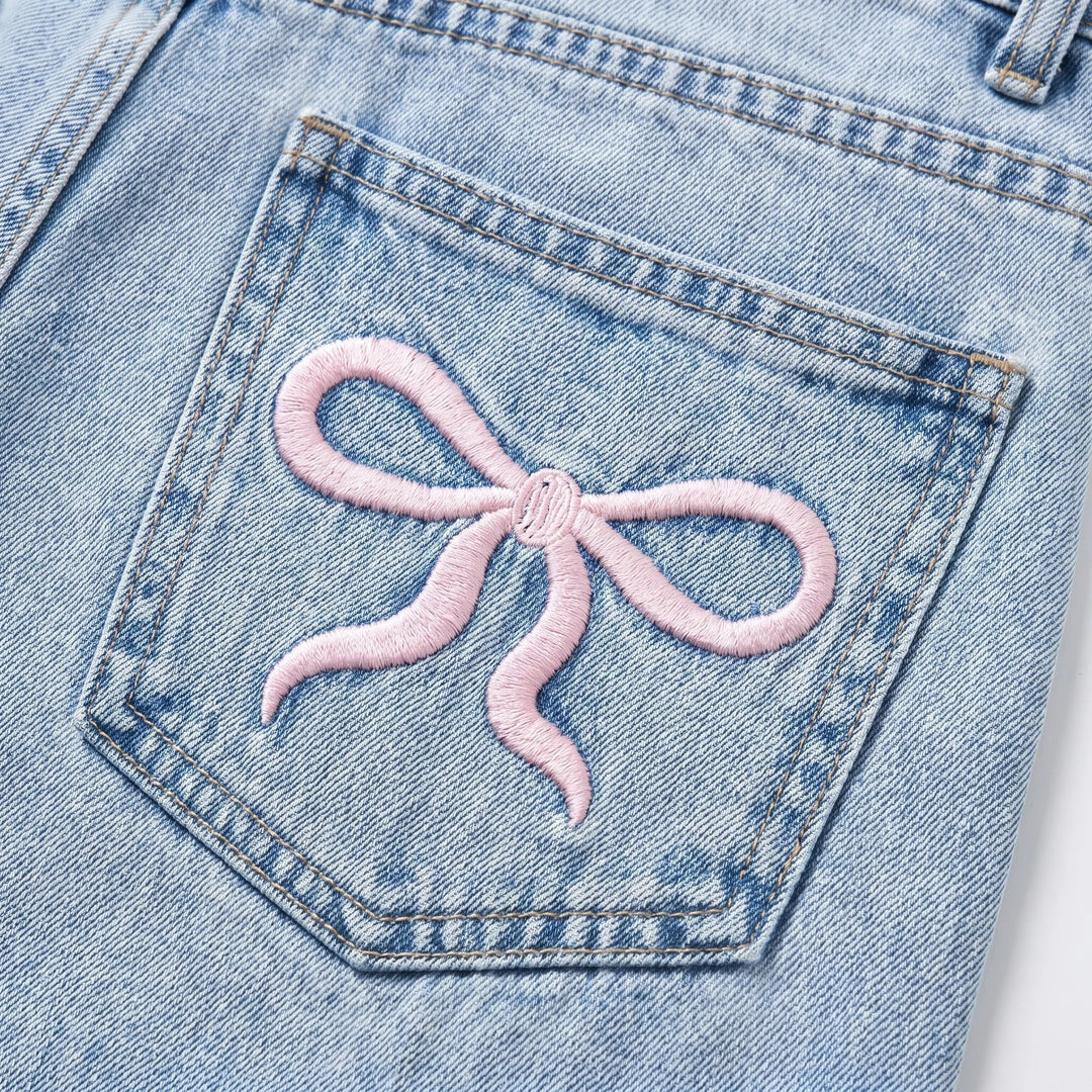 Light wash denim women's jeans, high-waisted, wide-leg, featuring charming cherry embroidery detail.