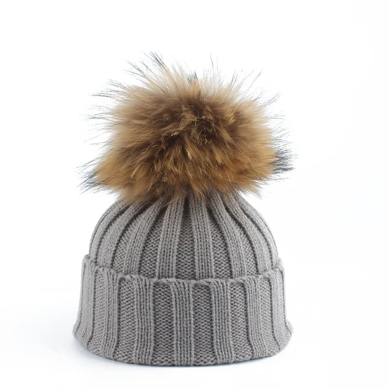 Cozy faux fur pom-pom beanie for women, warm knitted winter accessory.