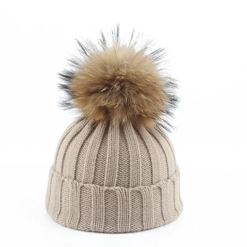 Warm knitted women's winter hat with a stylish pom-pom; essential for cold weather comfort.