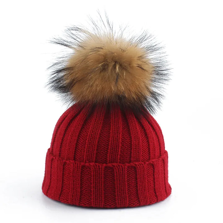 Cozy knitted women's pom-pom hat, a stylish and warm faux fur winter fashion accessory.