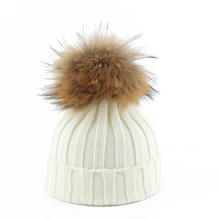 Luxurious knitted women's beanie with a soft faux fur pom-pom. A must-have cozy winter accessory.