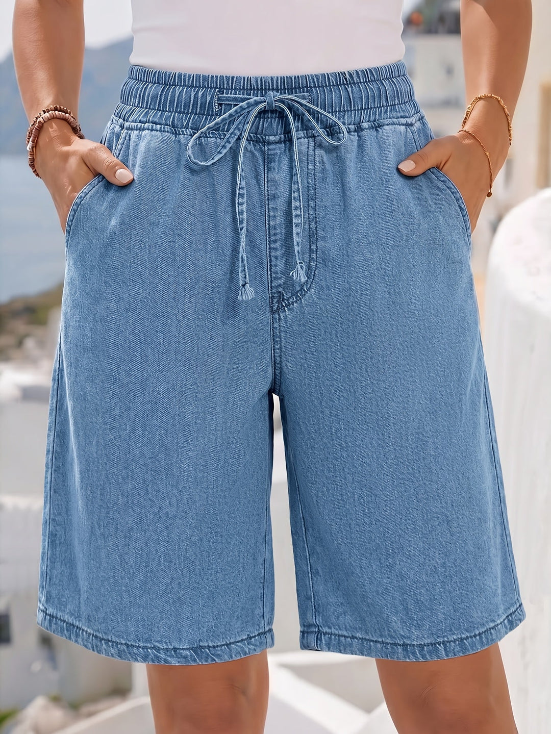 Relaxed fit light blue wide leg Bermuda shorts for women, featuring a stylish drawstring waist & soft fabric.