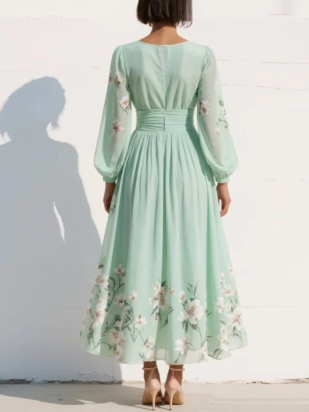 Flowy light green V-neck midi dress for women featuring delicate floral print, pleats, and comfortable balloon sleeves.