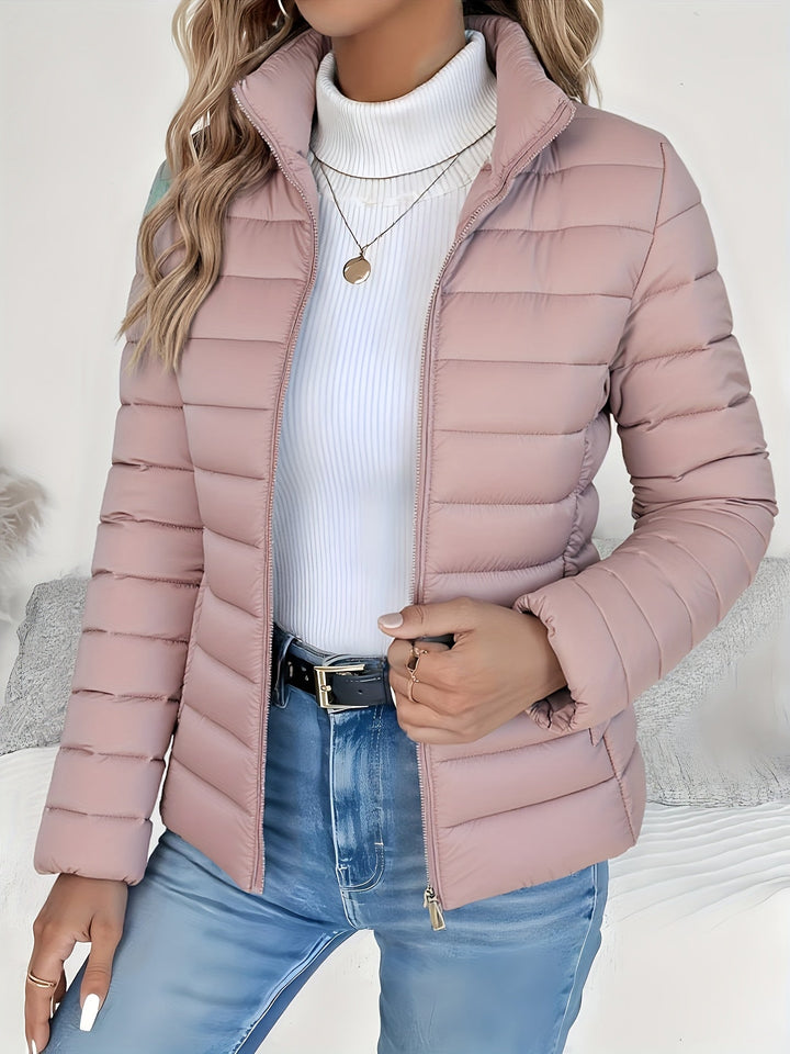 Stylish women's quilted jacket featuring a stand collar & long sleeves. Versatile lightweight outerwear for women.