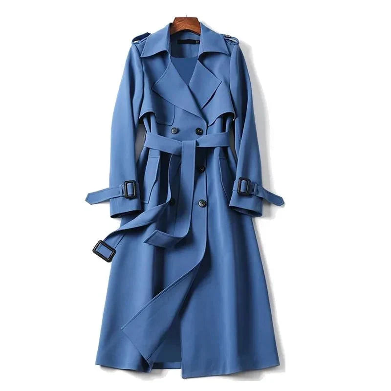 Women's long double-breasted trench coat with tie belt for elegant autumn outerwear.