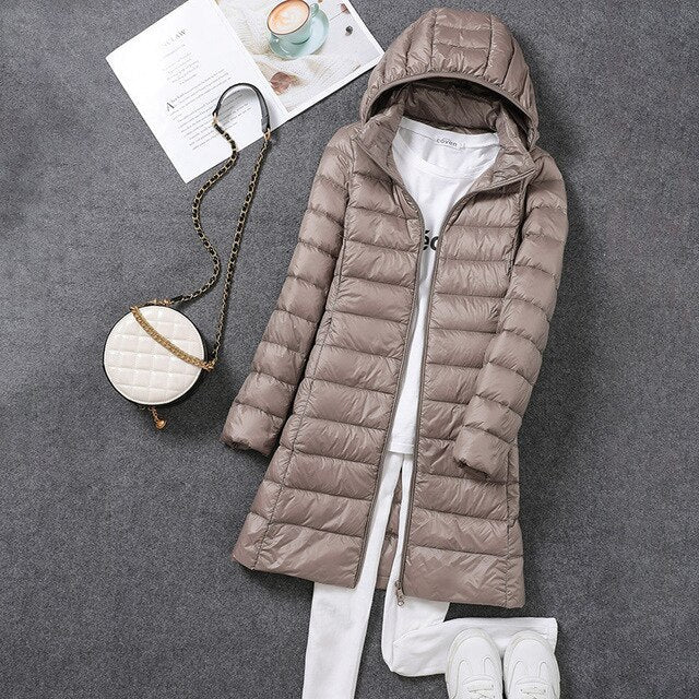 Woman wearing a long hooded puffer coat, essential winter outerwear for cozy cold weather.