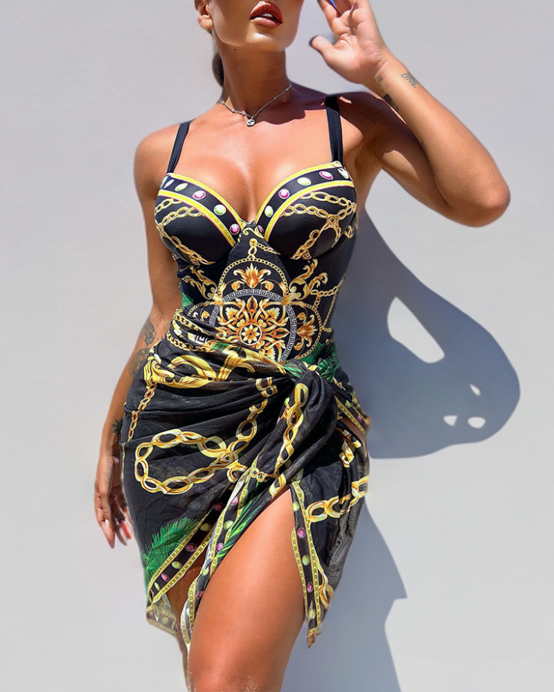 Women's luxurious baroque jewel print swimsuit & matching wrap skirt set. Elegant resort beachwear with chain detail.