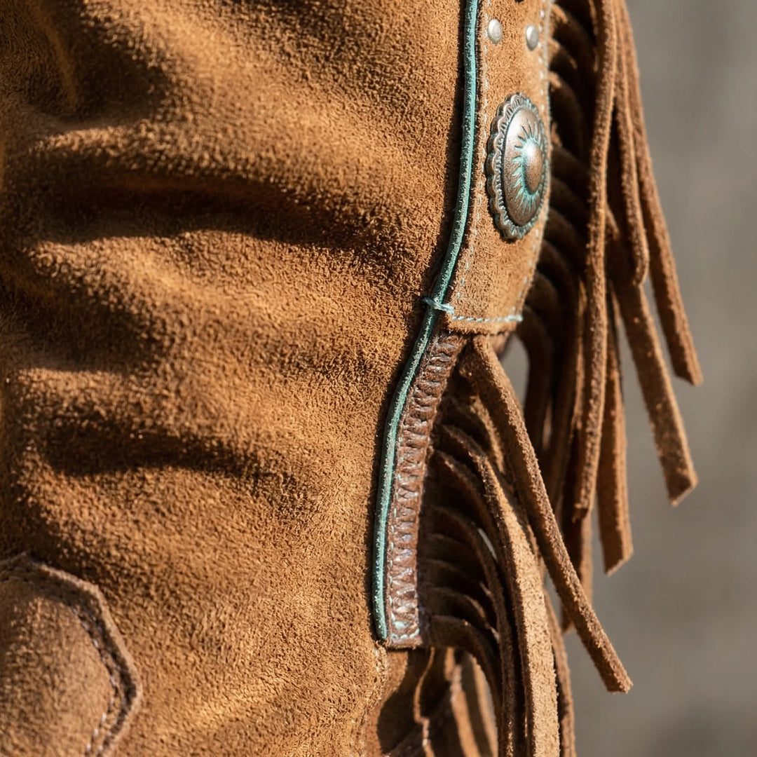Boho-style women's western boots with soft fringe, a stylish pointed toe, and a unique turquoise accent.