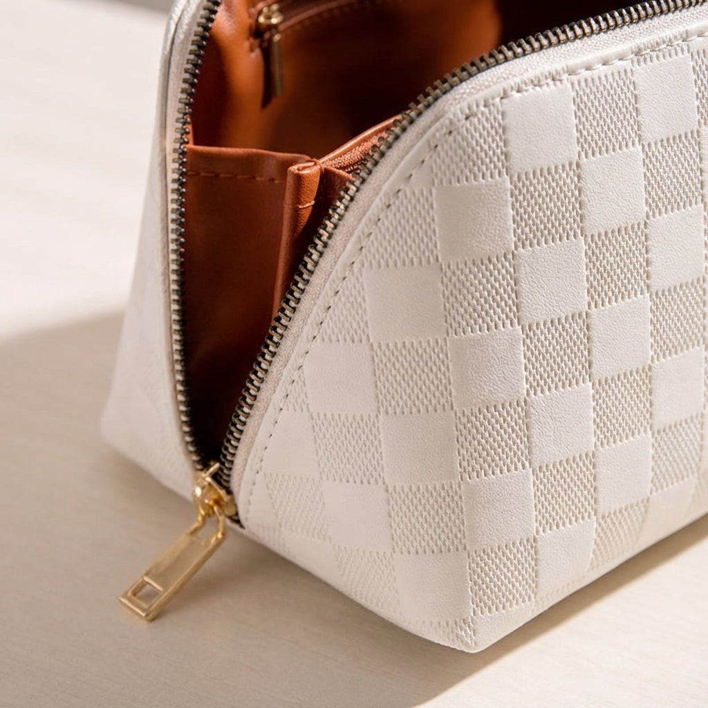 Cream women's travel makeup bag, organized multi-compartment pouch for portable beauty essentials.