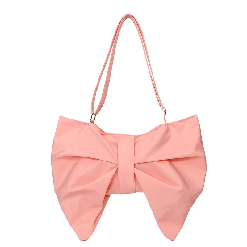 Close-up of the stylish oversized bow on a women's canvas tote bag. Playful and trendy handbag detail.