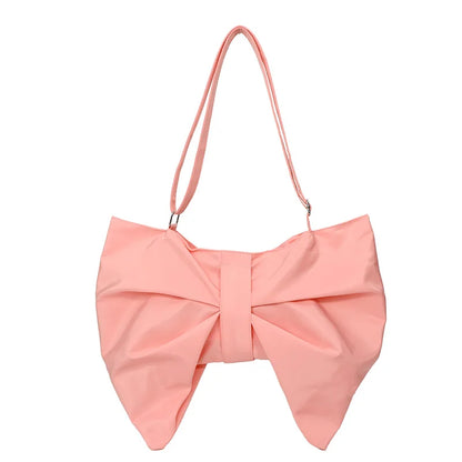 Close-up of the stylish oversized bow on a women's canvas tote bag. Playful and trendy handbag detail.