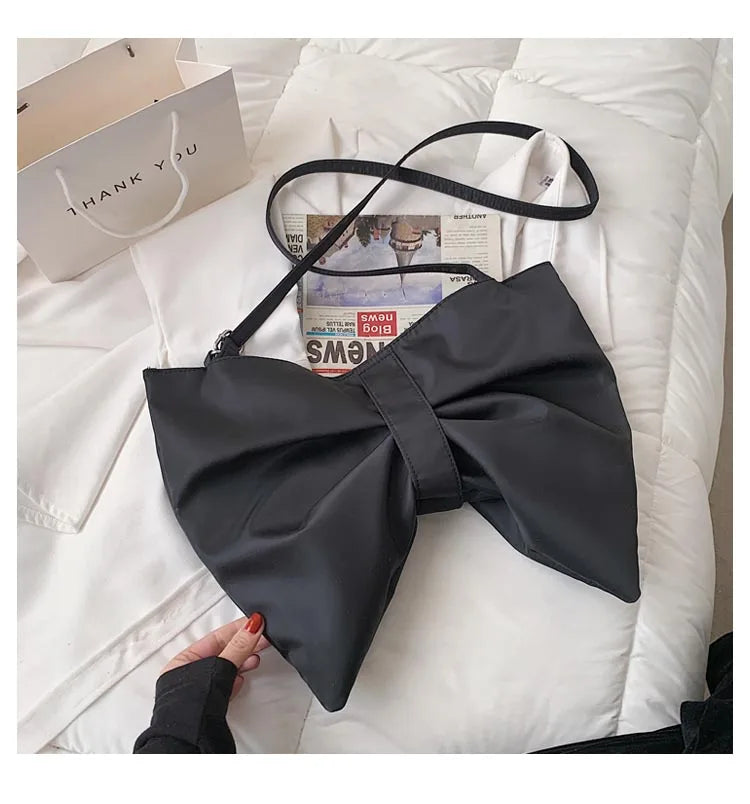 Stylish oversized canvas tote bag for women, featuring a large playful bow. A chic fashion accessory.