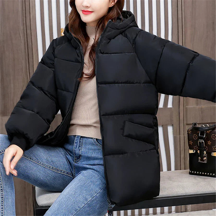 Modern women's padded winter jacket, oversized, with hood, for a stylish and warm cold-weather outfit.