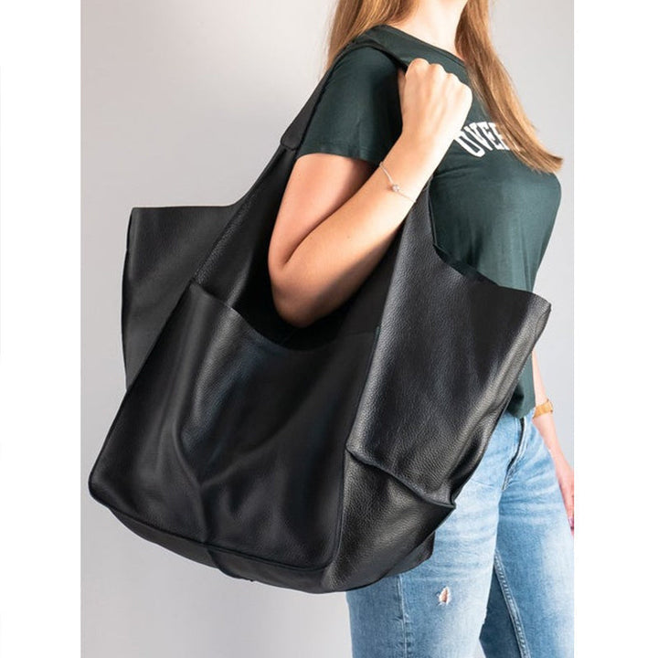 Women's oversized vintage leather shoulder bag in earthy tones, rustic and stylish.