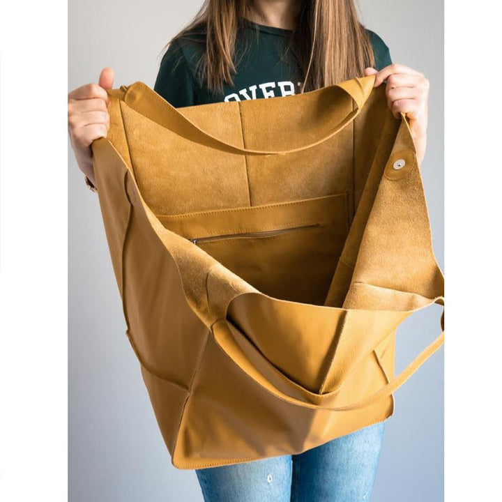 Chic tan oversized vintage leather shoulder bag, women's versatile fashion piece.