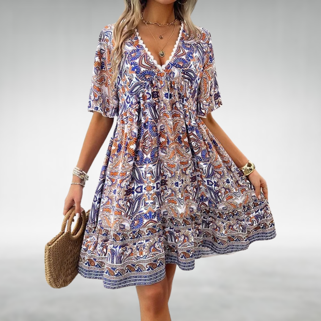 Relaxed fit V-neck boho mini dress with flutter sleeves, featuring a vibrant paisley print and lace trim.