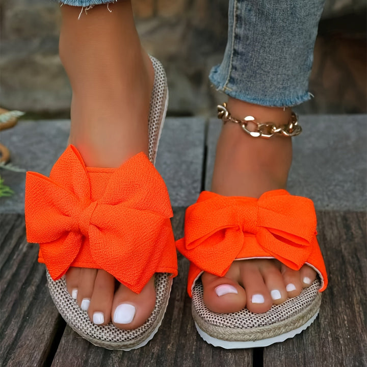 Close-up of elegant women's pearl slide sandals, showcasing pearl strap detail. Comfortable summer flats.