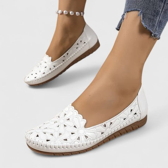 Chic women's ballet flats with a perforated floral cutout design, offering breathable comfort & sophisticated style.