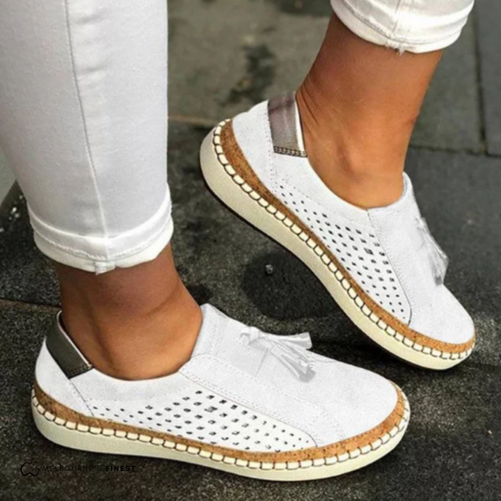 Comfortable women's slip-on loafers. Features perforated design, tassels, and a flat espadrille-style sole for casual wear.
