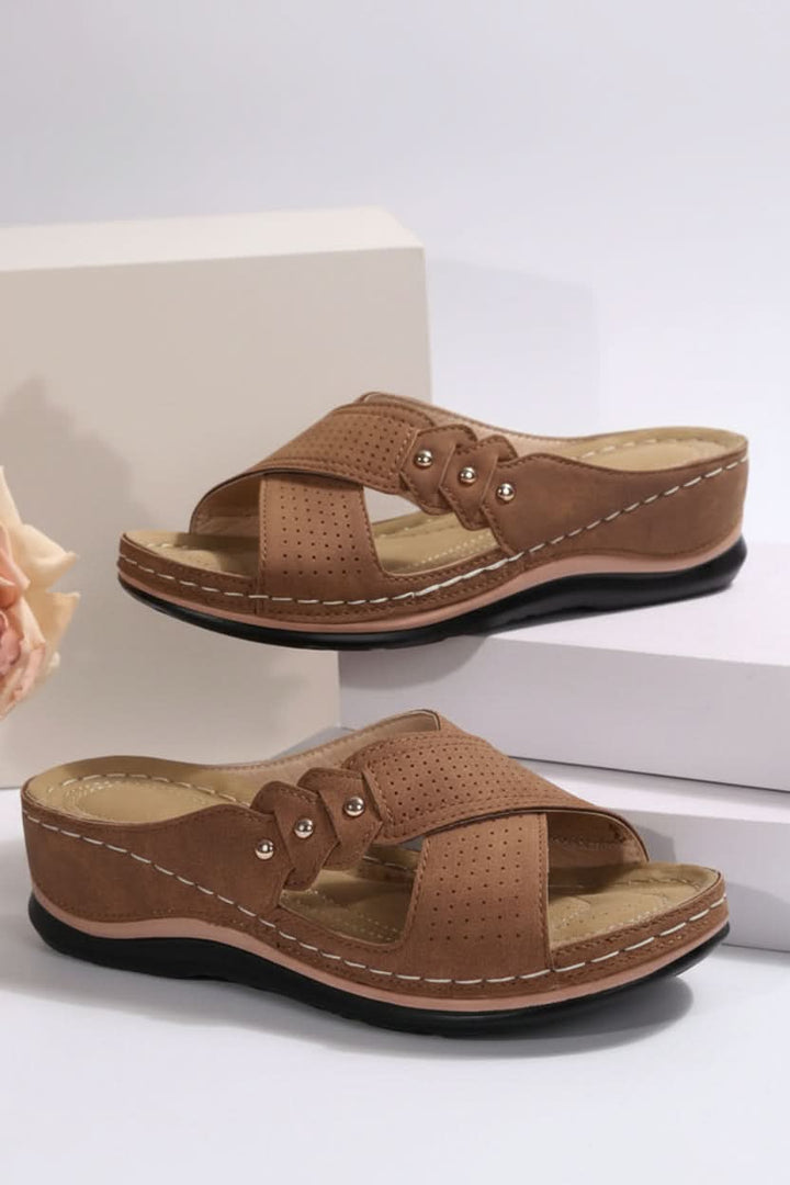 Perforated slip-on wedge sandals for women, providing breathable comfort for all-day wear.
